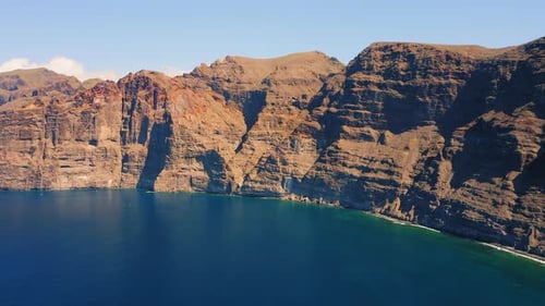 Amazing Aerial Flight Over Deep Ocean Blue Water Brown and Red Colored Huge Rocks