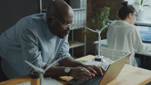 African American Engineer Working on Laptop in Open Space Office