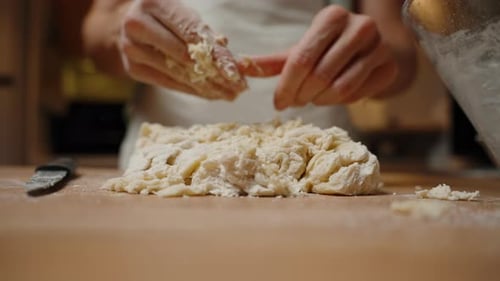 Adult Hands Kneading Dough in Kitchen