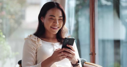 Woman Smiling and Using Smartphone Indoors