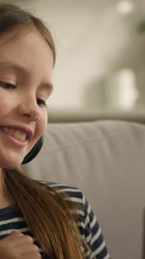 Active Happy Caucasian Little Girl Child Kid Daughter in Headphones Listening Music with Laptop