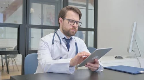 Mature Adult Doctor Using Digital Tablet in Hospital