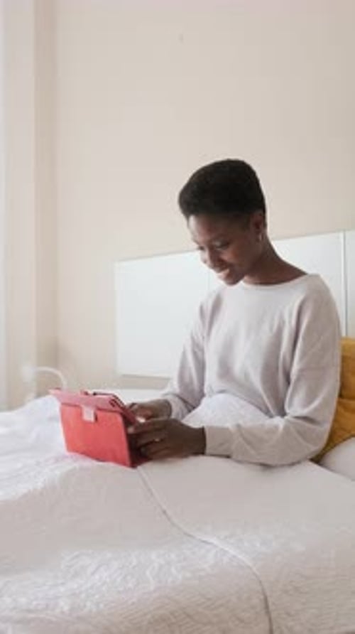 Woman Using Tablet Device in Bed