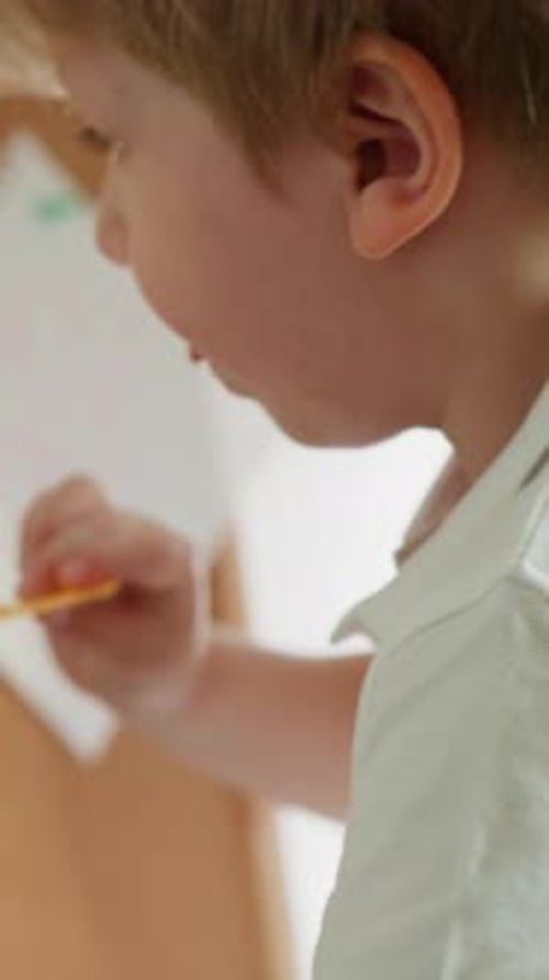 Boy Tries to Attach Piece of Paper to Board and Figure Falls