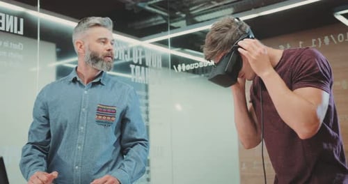 NEW YORK April 5 2017Adult Man with Beard and Young Attractive Man Testing Digital Glasses Happy