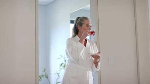 Woman in Robe Sips Drink Indoors