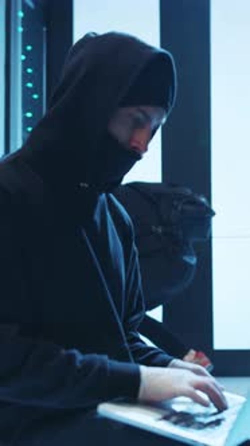 Two Anonymous Men in Hoodies Hacking Servers