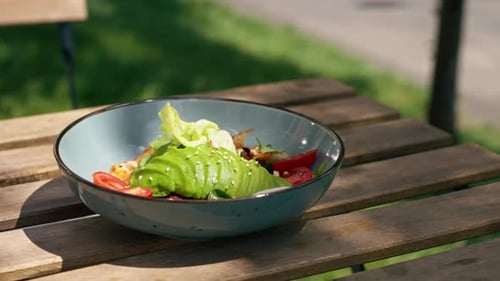 Vertical Video in a Restaurant on the Street a Chef in a Black Uniform Sits at a Wooden Table and