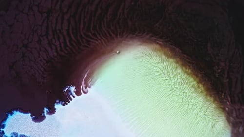 Ink in water art with swirling pink, green and blue colors, abstract background