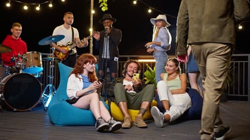 Young adults enjoy music at night rooftop party