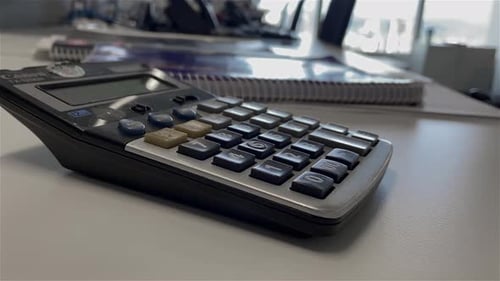Close up of a calculator sitting an a desk in an empty office building during COVI-19 lockdown
