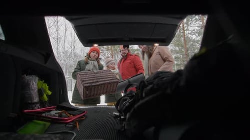 Family Unloads Car for Winter Adventure in Forest