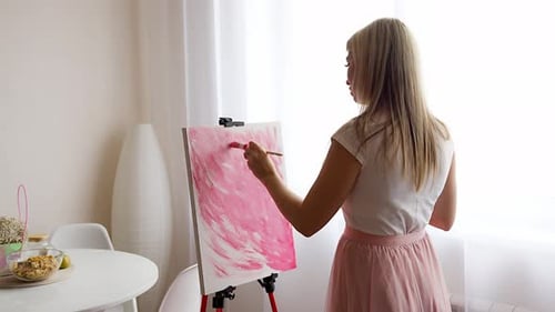 Blonde Woman Painting Pink Canvas Indoors