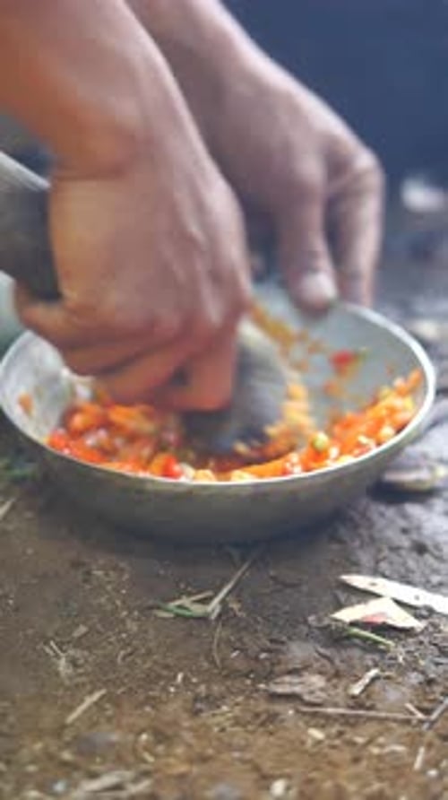 as mãos de um homem estão fazendo molho de pimenta vermelha quente