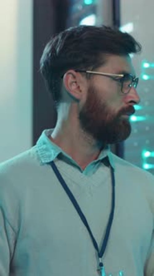 A Professional Man Wearing Glasses and a Stylish Sweater in a Modern Office Space
