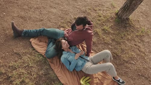 Couple having good time at picnic in the park. View from above