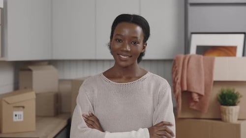 Smiling Woman in Kitchen with Moving Boxes