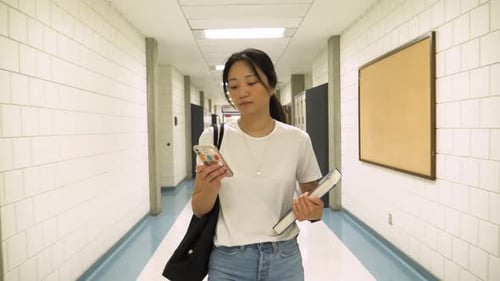 Female College Student Using Smart Phone in School Corridor Adult
