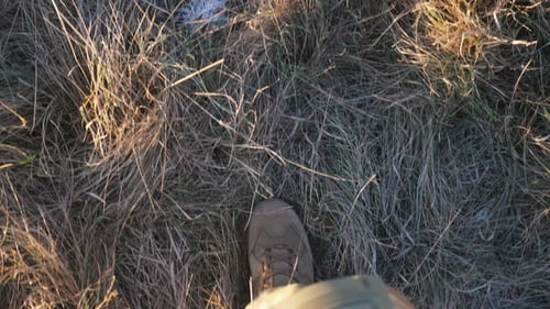 Point of View to Female Feet of Ukrainian Soldiery Going in Brown Boots Through Dry Grass at