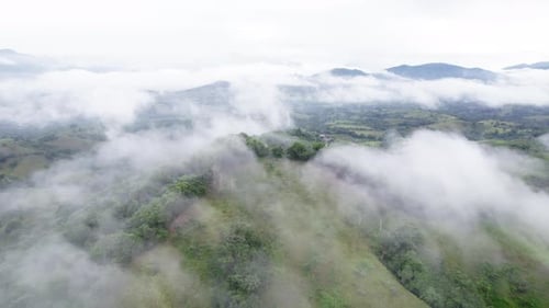 Hill surrounded with fog and clouds