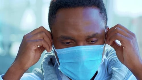Close Up Smiling Young African American Man Removes Protective Face Mask Stand Look at Camera Happy
