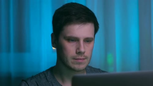 Mann arbeitet nachts am Laptop