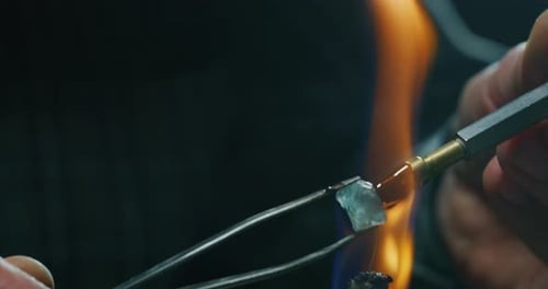 Slow motion macro of experienced goldsmith working on high quality aquamarine stones selected for