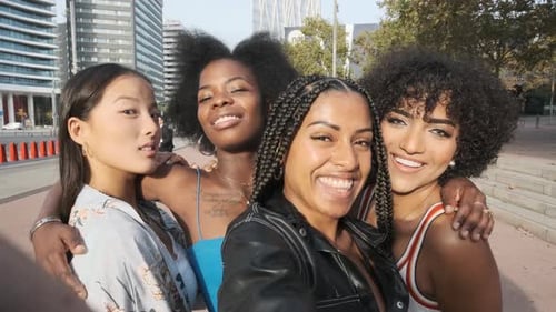 Amigos multiétnicos con una mujer transgénero posando mientras se toman una selfie