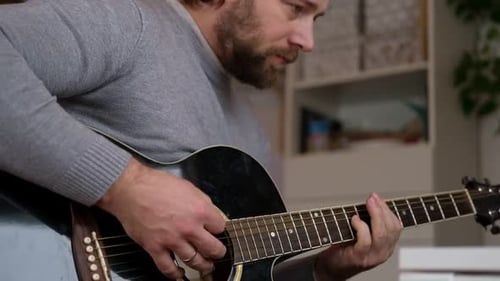 Man Playing Acoustic Guitar Indoors, Strumming