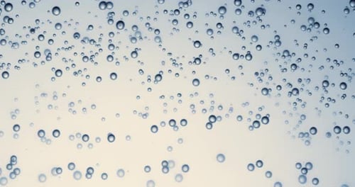 Many water bubbles in blue water close up, abstract water wave with bubbles in slow motion.