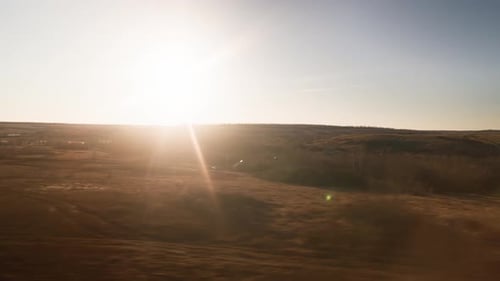 Blick aus dem Fenster, der den Zug entlang der Bahngleise bei einem wunderschönen Sonnenuntergang bewegt