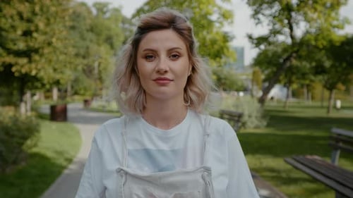 Hands touching pregnant belly while on a walk.