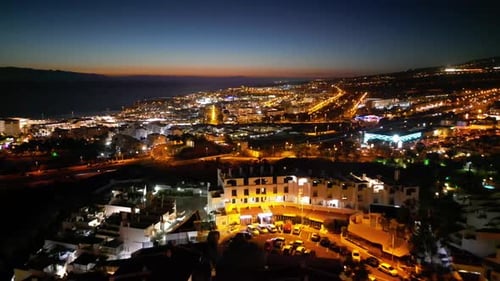Breathtaking backward night flights over residential areas with a distant highway. Thousands of stre