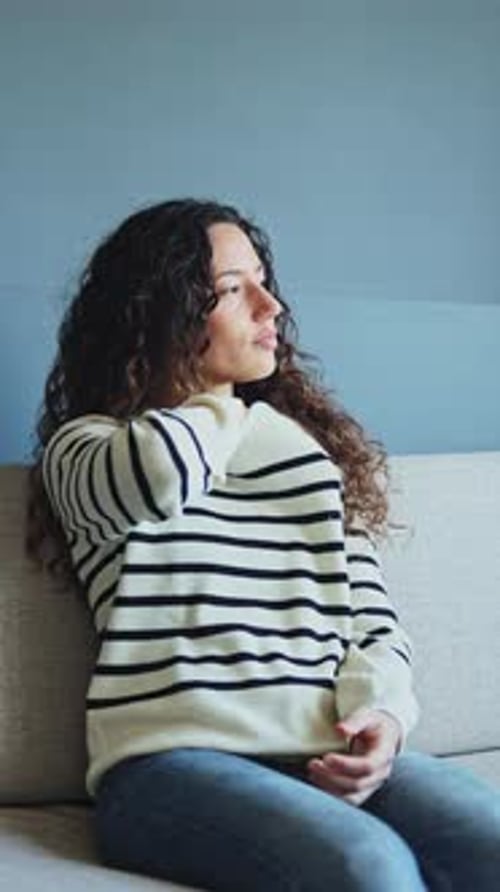 Femme se sentant malade en prenant la température sur le canapé