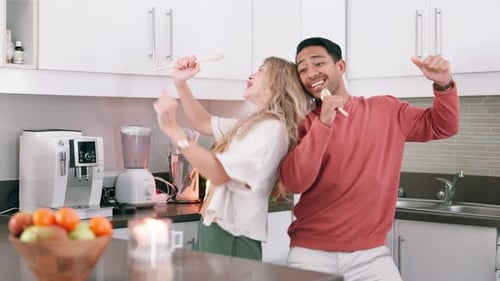 Happy Couple Singing and Dancing in Kitchen