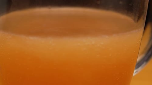 Close Up of Orange Beverage With Bubbles