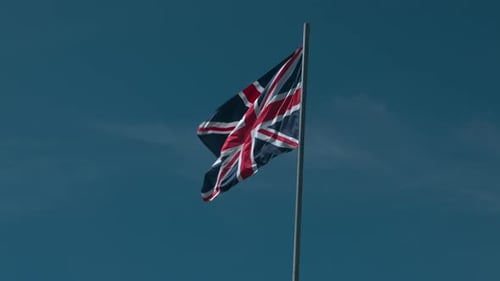 Union Jack Flag Flying Against Blue Sky