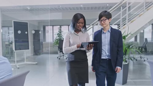 Two Young Male and Female Specialiasts Walk in the Office Holding a Tablet Computer, Ignore Their C