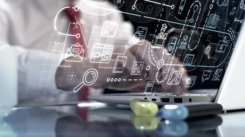 Businessman Using Laptop with Digital Business Icons Overlay