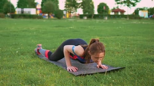 Young Woman Doing Push Ups Doing Fitness Exercises Using Elastic Band in Fresh Air in Urban Area