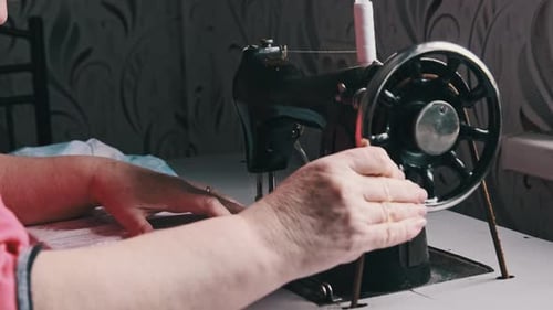 Person Using Vintage Sewing Machine in Home