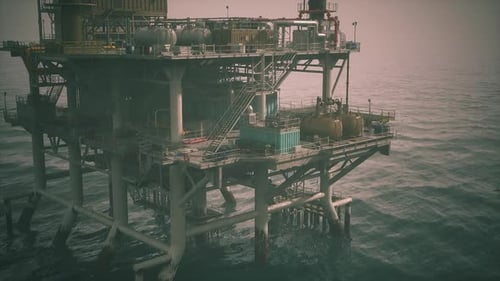Offshore Oil Rig Operating Over Calm Seas at Dusk During the Evening Hours
