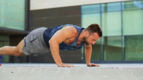 Fitness, Sport And Training Concept - Young Man Doing Push Ups On City Street