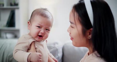 Mother Comforting Her Baby in Living Room