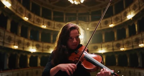 Woman Plays Violin in Ornate Theater