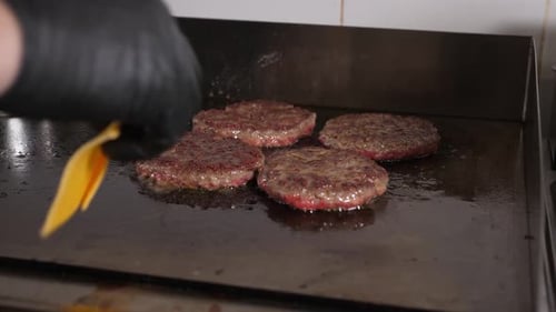 Burger Patties Cooking on Grill with Melting Cheese