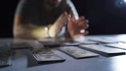 Man in Handcuffs with Stacks of Money