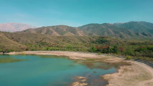 Aerial drone flying over a blue water lake with mountains landscape