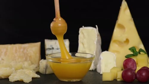 Cheese Honey and Grapes. Man tasting cheese with honey and grapes
