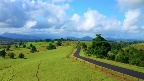 Country Road Winding Gracefully Amid Vibrant Green Slopes